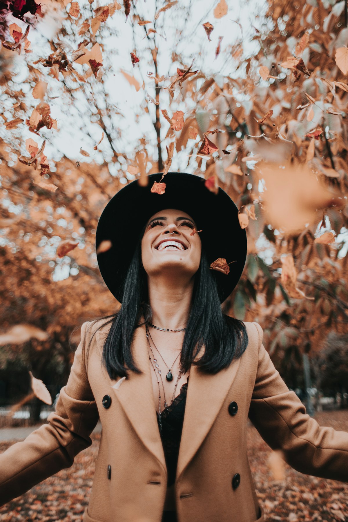 Autumn outfit laid out with brown suede boots, a knit sweater and a checked skirt