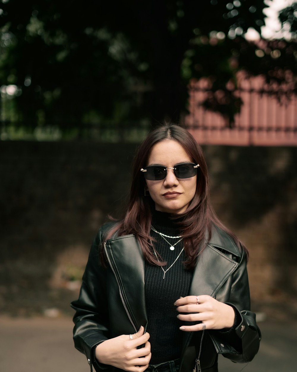 Woman in a leather jacket and sunglasses on a city street