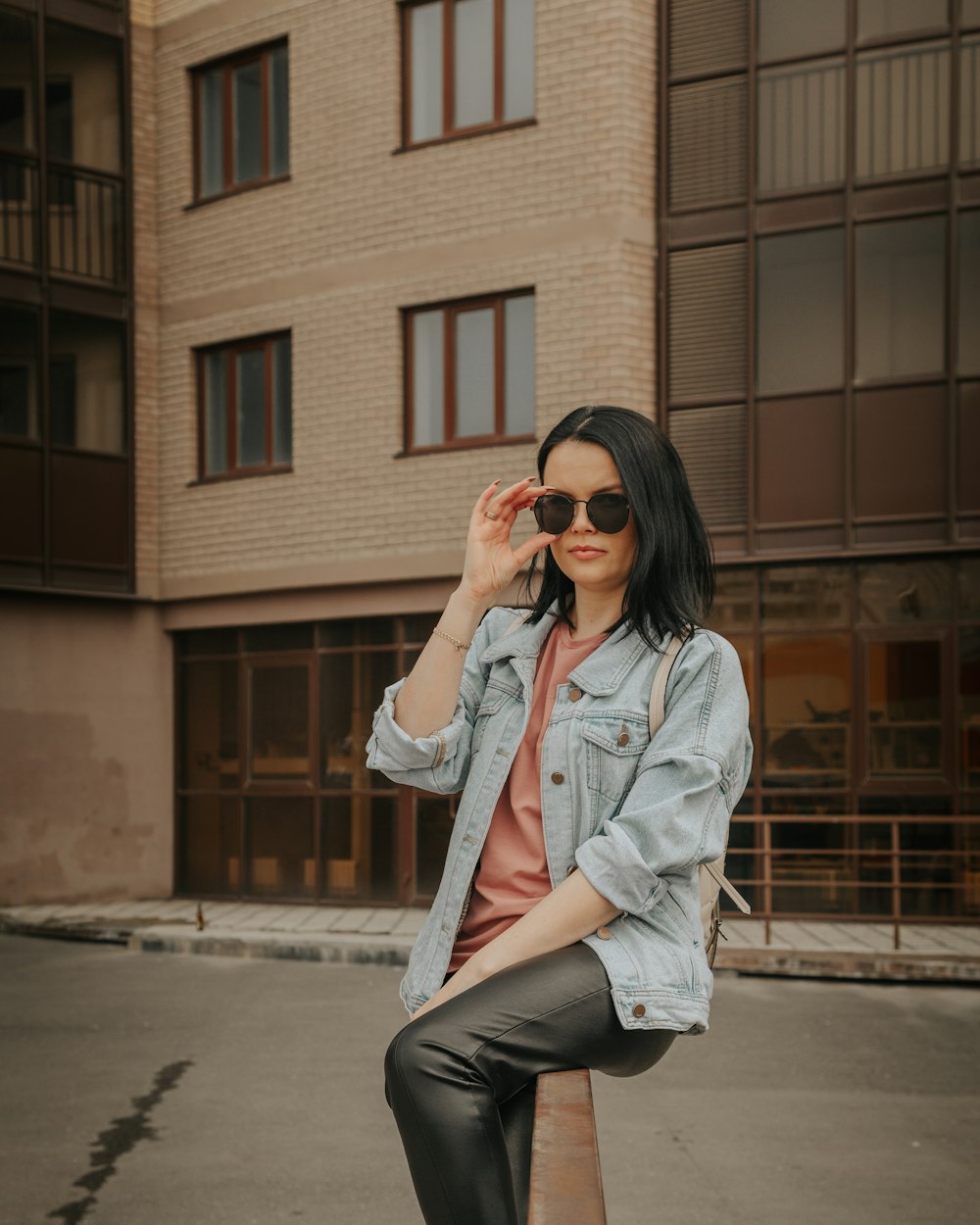 Woman in a denim jacket and jeans wearing sunglasses